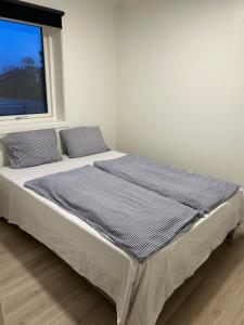 a large bed in a room with a window at GHAR-New 2 bedrooms apartment near airport and Oslo city-free parking in Klofta