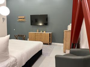 a bedroom with a bed and a tv and a chair at Hotel Royal in Long Beach