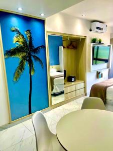a room with a table and a palm tree mural at HOTEL NAVEGANTES VISTA PARA MAR Boa Viagem in Recife