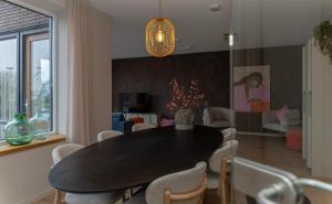 a dining room with a black table and chairs at Oan 'e Haven in Oudega
