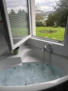 a sink with a water fountain in it next to a window at Ferienwohnung Sorpesee in Sundern +24 photos