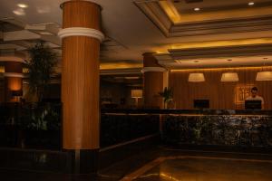 a hotel lobby with a column and a bar at Hotel Franco Blumenau in Blumenau