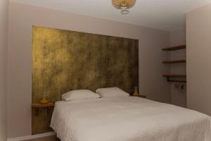 a bedroom with a white bed and a painting on the wall at Oan 'e Haven in Oudega +9 photos
