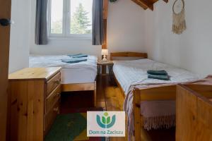 two beds in a room with a sign on the floor at Dom na Zaciszu Charzykowy in Charzykowy