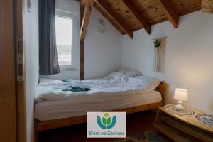 a small bedroom with a bed with a sign on it at Dom na Zaciszu Charzykowy in Charzykowy