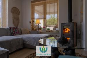 a living room with a couch and a fire place at Dom na Zaciszu Charzykowy in Charzykowy