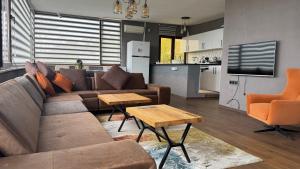 a living room with a couch and a table and a kitchen at Uludağ Vadi Konakları in Bursa