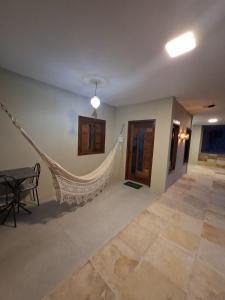 a room with a hammock in the middle of a room at Pousada Breizh Brasil Lençois - BBL in Barreirinhas