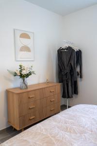 a bedroom with a dresser and a coat hanging on a wall at la pause soleil, villa climatisée, avec jardin et parkings privés, à 5 mn de la mer, au calme in Martigues