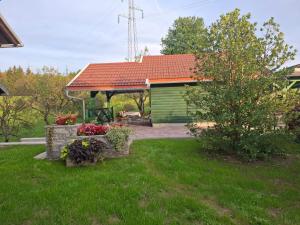 ein grüner Schuppen mit orangefarbenem Dach in einem Garten in der Unterkunft FILUTE in Vrbovsko