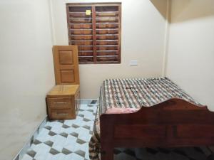 a bedroom with a bed and a dresser and a window at Thamilarasan inn in Jaffna