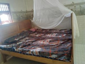 a bed with a mosquito net on top of it at Thamilarasan inn in Jaffna