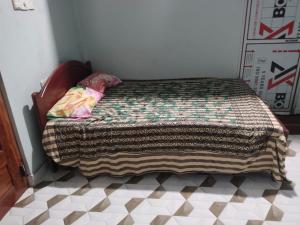 a small bed in a room with aocemetery at Thamilarasan inn in Jaffna