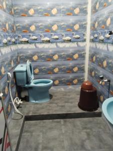 a bathroom with a blue toilet with fish on the wall at Thamilarasan inn in Jaffna