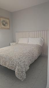 a bedroom with a bed with a white comforter at Apartamento Candil in Puerto Naos