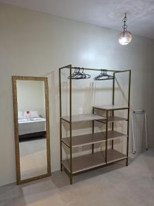 a mirror and shelves in a room with a bed at Pousada Breizh Brasil Lençois - BBL in Barreirinhas