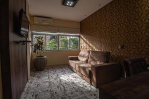 a living room with a couch and a window at Hotel Franco Blumenau in Blumenau