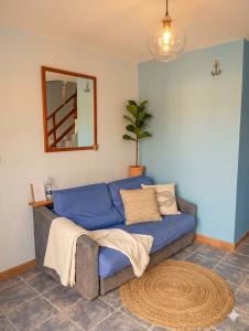 a blue couch in a living room with a mirror at Águila Marina Suites in Chichiriviche