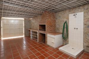 a bathroom with a tile floor and a brick wall at Águila Marina Suites in Chichiriviche +11 photos