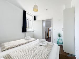 two beds in a room with white walls and a window at Hus Krüüzpadd boben in Cuxhaven