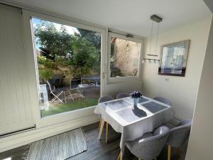 a dining room with a table and chairs and a window at Clos Belin in Chavornay