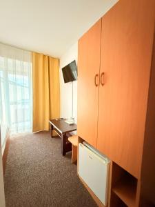 a hotel room with a cabinet and a desk at Vila Gymy in Constanţa