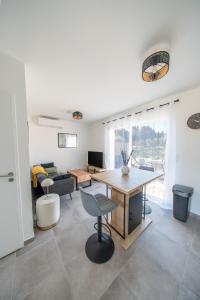 a living room with a table and a couch at la pause soleil, villa climatisée, avec jardin et parkings privés, à 5 mn de la mer, au calme in Martigues