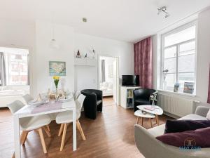 a living room with a white table and chairs at Hus Krüüzpadd unnen in Cuxhaven