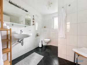 a white bathroom with a sink and a toilet at Hus Krüüzpadd unnen in Cuxhaven +17 photos