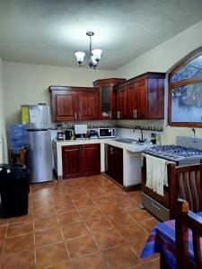 a kitchen with wooden cabinets and a counter top at Hospedaje in San Pablo La Laguna