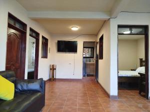 a living room with a couch and a flat screen tv at Hospedaje in San Pablo La Laguna