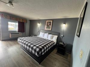 a bedroom with a bed with a checkered blanket at Travel Inn in Broadview
