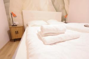 a bedroom with two white towels on a bed at St Antoni Suite 4 in Eisenstadt