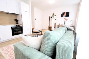 a living room with a green and white couch at St Antoni Suite 4 in Eisenstadt