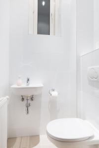 Un baño blanco con lavabo e inodoro. en HeyMi Apartments Stephansdom, en Viena