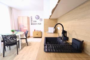 a kitchen with a black sink and a table at St Antoni Suite 4 in Eisenstadt +15 photos