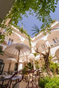 a patio with tables and umbrellas in front of a building at Casa Amor Olhão in Olhão