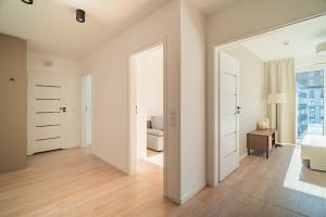 a bedroom with white walls and wooden floors and white furniture at Prime Apartments Gdańsk in Gdańsk +59 photos