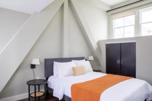 a bedroom with a large bed with an orange blanket at Downtown Luxury 1BR Loft · Walkable · Sleeps 4 in Milwaukee