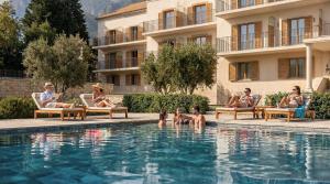 a group of people sitting around a swimming pool at The Bristol Bol - NEW IN 2026 in Bol