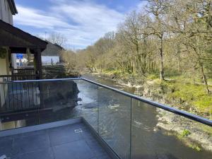 a balcony with a view of a river at Beautiful River View with Sauna in Llandysul