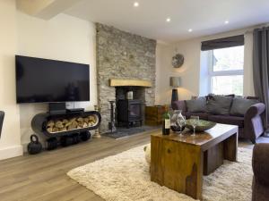a living room with a couch and a fireplace at Beautiful River View with Sauna in Llandysul