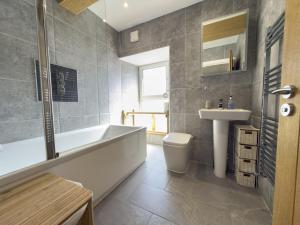 a bathroom with a tub and a toilet and a sink at Beautiful River View with Sauna in Llandysul +38 photos