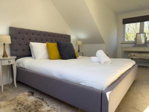a bedroom with a large bed with yellow and black pillows at Beautiful River View with Sauna in Llandysul