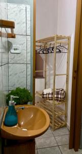 a bathroom with a sink and a shelf with towels at Casa Freitas - suíte 1 in Extrema