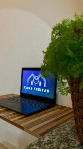 a laptop computer sitting on a wooden table with a plant at Casa Freitas - suíte 1 in Extrema