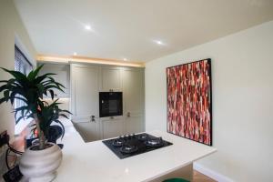 a kitchen with a potted plant and a painting on the wall at Unique 3 Bed Home, Stewarton in Stewarton