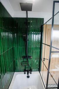 a shower with green tiled walls and a bath tub at Unique 3 Bed Home, Stewarton in Stewarton