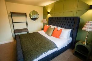 a bedroom with a bed with orange pillows and a mirror at Unique 3 Bed Home, Stewarton in Stewarton