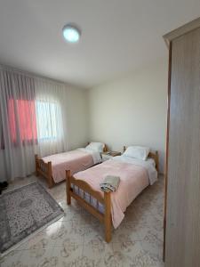 a bedroom with two beds and a window at Hostel Rinas in Rinas